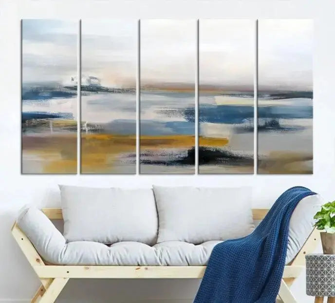 A captivating 3-panel abstract landscape wall art in modern blue, gold, and white hues graces the dark wall, enhancing the space with a touch of contemporary decor.