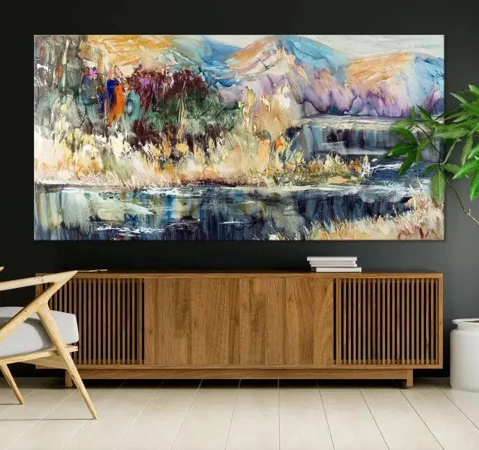 A vibrant Abstract Landscape Waterfall Canvas Art adorns the wall in this cozy living room. This 3-panel large wall art enhances the inviting space's vivid collection. This premium quality, ready-to-hang print is perfect for a living room, office, or lounge.