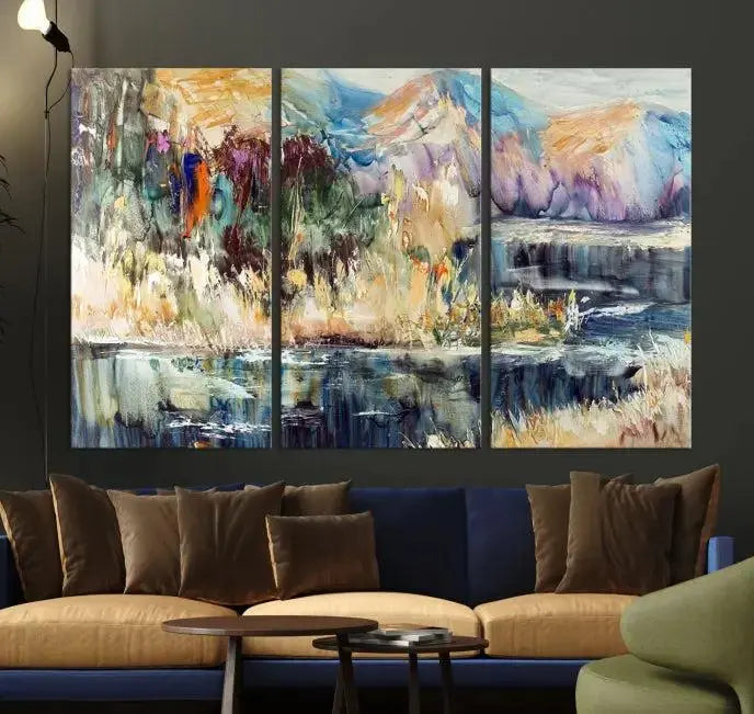 A vibrant Abstract Landscape Waterfall Canvas Art adorns the wall in this cozy living room. This 3-panel large wall art enhances the inviting space's vivid collection. This premium quality, ready-to-hang print is perfect for a living room, office, or lounge.