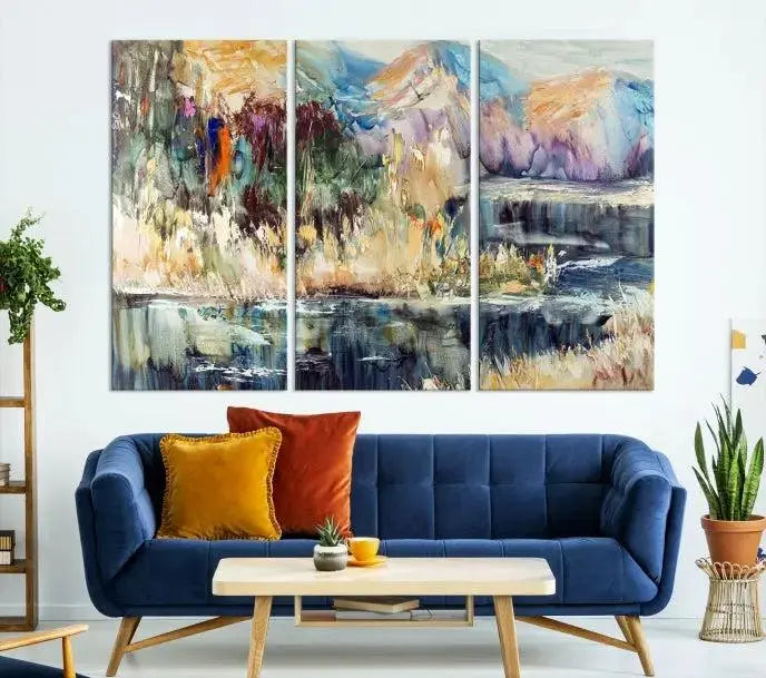 A vibrant Abstract Landscape Waterfall Canvas Art adorns the wall in this cozy living room. This 3-panel large wall art enhances the inviting space's vivid collection. This premium quality, ready-to-hang print is perfect for a living room, office, or lounge.