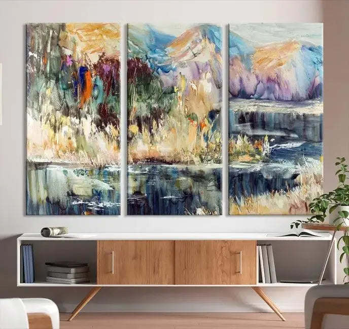 A vibrant Abstract Landscape Waterfall Canvas Art adorns the wall in this cozy living room. This 3-panel large wall art enhances the inviting space's vivid collection. This premium quality, ready-to-hang print is perfect for a living room, office, or lounge.