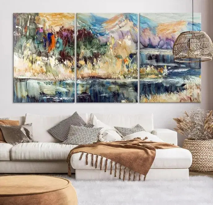 A vibrant Abstract Landscape Waterfall Canvas Art adorns the wall in this cozy living room. This 3-panel large wall art enhances the inviting space's vivid collection. This premium quality, ready-to-hang print is perfect for a living room, office, or lounge.