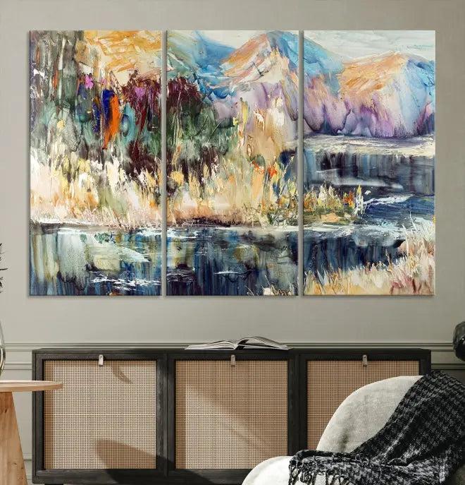 A vibrant Abstract Landscape Waterfall Canvas Art adorns the wall in this cozy living room. This 3-panel large wall art enhances the inviting space's vivid collection. This premium quality, ready-to-hang print is perfect for a living room, office, or lounge.