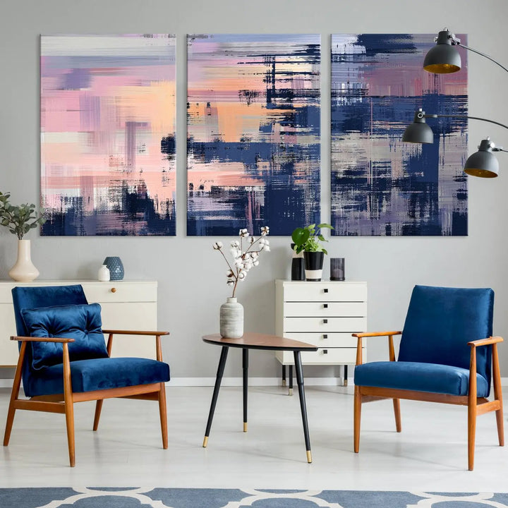 The Abstract Painting Wall Art Canvas Print Split Canvas Art, featuring pink, peach, and navy blue tones, decorates the wall. This museum-quality canvas is equipped with a UV-protective coating to preserve its vivid colors and comes ready to hang for your convenience.