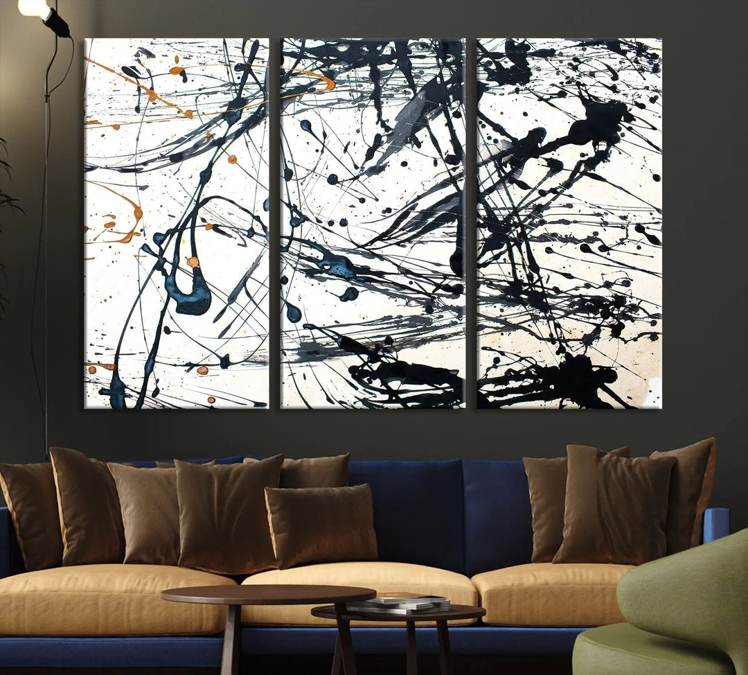 The Abstract Splash Wall Art Canvas Print, featuring a triptych design with blue and black splatters on a white background, is crafted on museum-quality canvas. It includes a UV-protective coating to maintain its vibrant appearance over time.