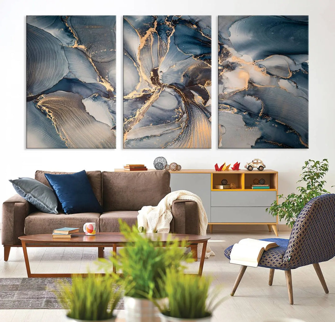 The Abstract Wall Art Canvas Print for Modern Home Decor is a striking feature in the modern living room. It showcases a blue and gold triptych design on museum-quality canvas, complete with a UV-protective coating to ensure long-lasting vibrancy.