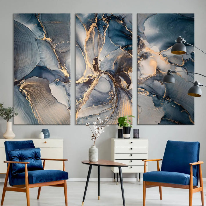 The Abstract Wall Art Canvas Print for Modern Home Decor is a striking feature in the modern living room. It showcases a blue and gold triptych design on museum-quality canvas, complete with a UV-protective coating to ensure long-lasting vibrancy.