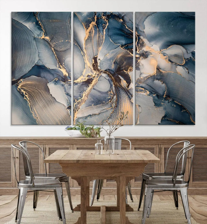 The Abstract Wall Art Canvas Print for Modern Home Decor is a striking feature in the modern living room. It showcases a blue and gold triptych design on museum-quality canvas, complete with a UV-protective coating to ensure long-lasting vibrancy.