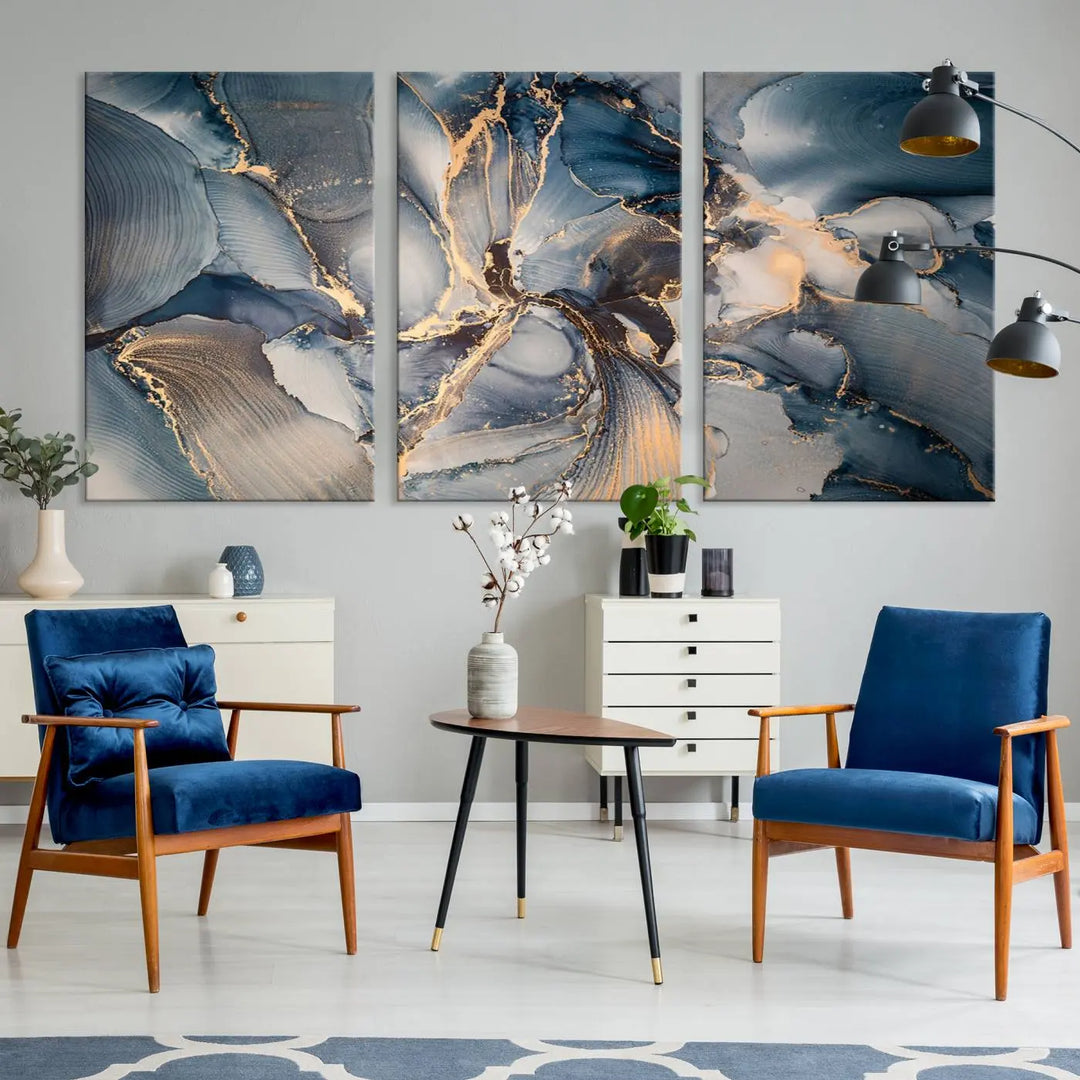 The Abstract Wall Art Canvas Print for Modern Home Decor is a striking feature in the modern living room. It showcases a blue and gold triptych design on museum-quality canvas, complete with a UV-protective coating to ensure long-lasting vibrancy.