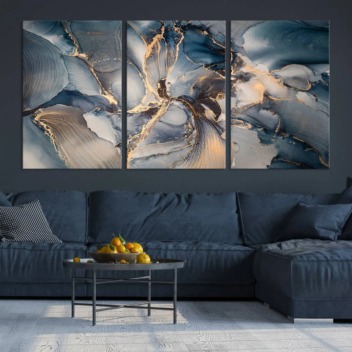 The Abstract Wall Art Canvas Print for Modern Home Decor is a striking feature in the modern living room. It showcases a blue and gold triptych design on museum-quality canvas, complete with a UV-protective coating to ensure long-lasting vibrancy.