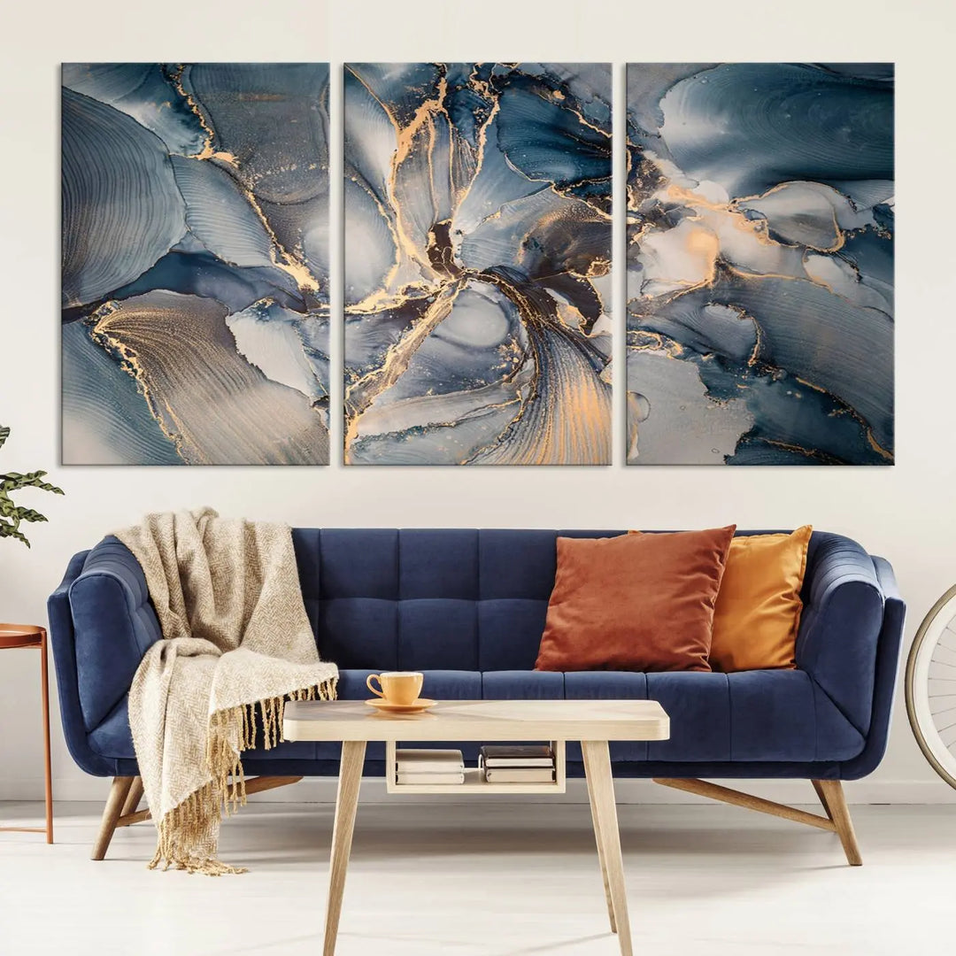 The Abstract Wall Art Canvas Print for Modern Home Decor is a striking feature in the modern living room. It showcases a blue and gold triptych design on museum-quality canvas, complete with a UV-protective coating to ensure long-lasting vibrancy.