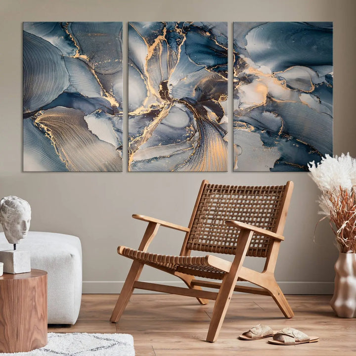 The Abstract Wall Art Canvas Print for Modern Home Decor is a striking feature in the modern living room. It showcases a blue and gold triptych design on museum-quality canvas, complete with a UV-protective coating to ensure long-lasting vibrancy.