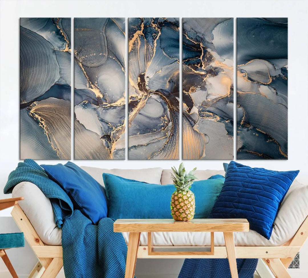 The Abstract Wall Art Canvas Print for Modern Home Decor is a striking feature in the modern living room. It showcases a blue and gold triptych design on museum-quality canvas, complete with a UV-protective coating to ensure long-lasting vibrancy.