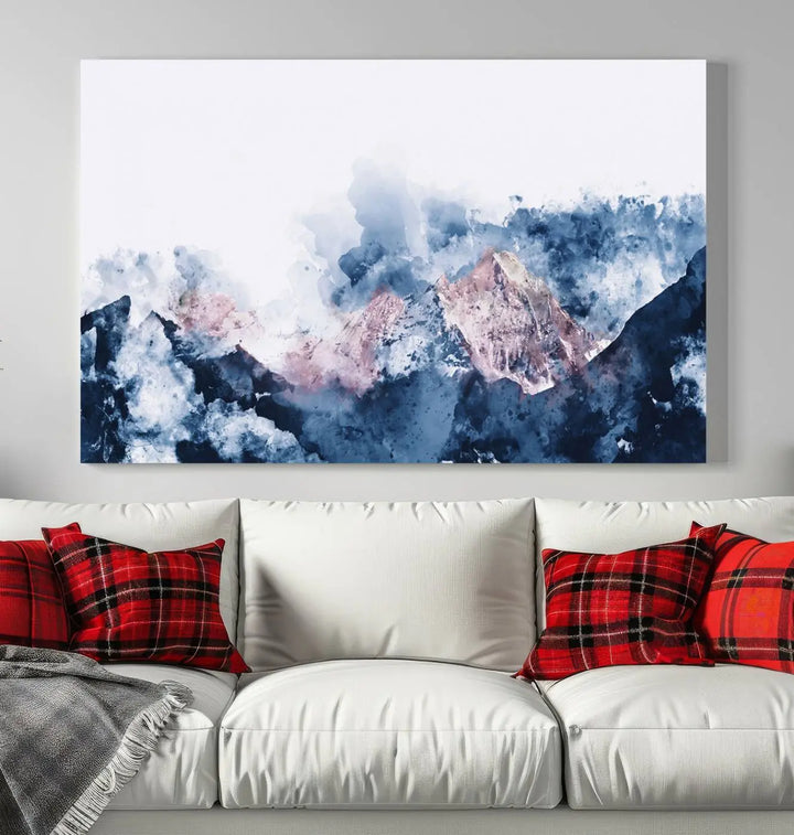 The modern living room features a framed triptych art on a dark wall, complemented by the Abstract Watercolor Mountain Landscape Art Canvas Print, which adds elegance and depth to the space.