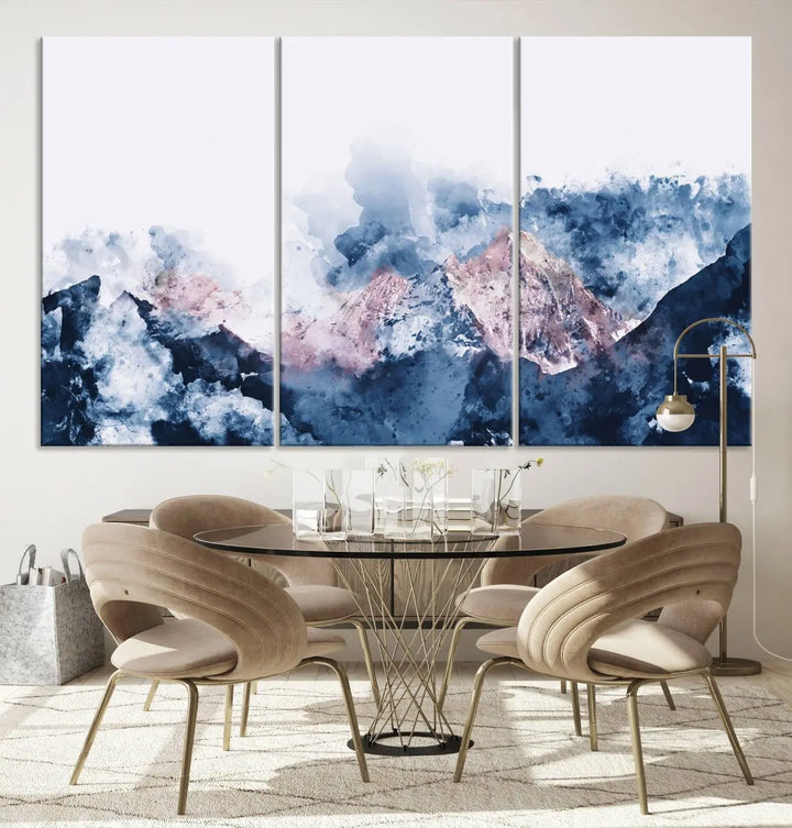 The modern living room features a framed triptych art on a dark wall, complemented by the Abstract Watercolor Mountain Landscape Art Canvas Print, which adds elegance and depth to the space.