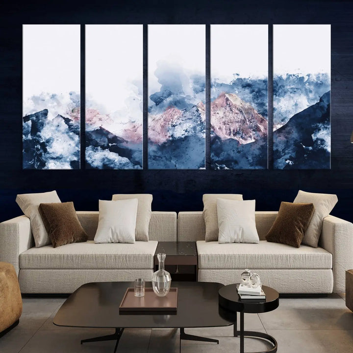 The modern living room features a framed triptych art on a dark wall, complemented by the Abstract Watercolor Mountain Landscape Art Canvas Print, which adds elegance and depth to the space.