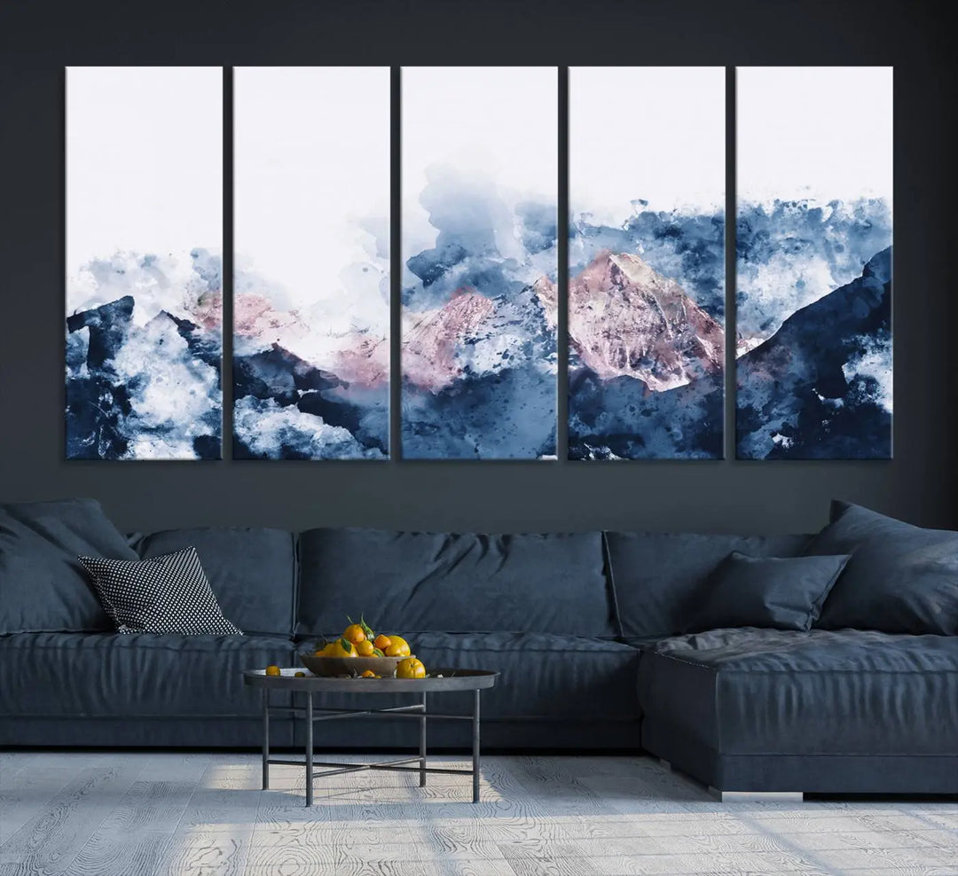 The modern living room features a framed triptych art on a dark wall, complemented by the Abstract Watercolor Mountain Landscape Art Canvas Print, which adds elegance and depth to the space.