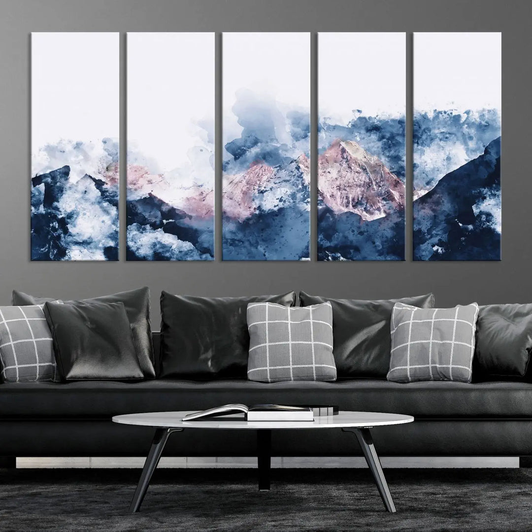 The modern living room features a framed triptych art on a dark wall, complemented by the Abstract Watercolor Mountain Landscape Art Canvas Print, which adds elegance and depth to the space.