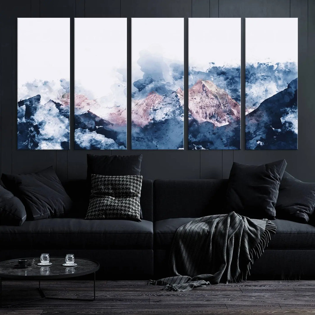 The modern living room features a framed triptych art on a dark wall, complemented by the Abstract Watercolor Mountain Landscape Art Canvas Print, which adds elegance and depth to the space.