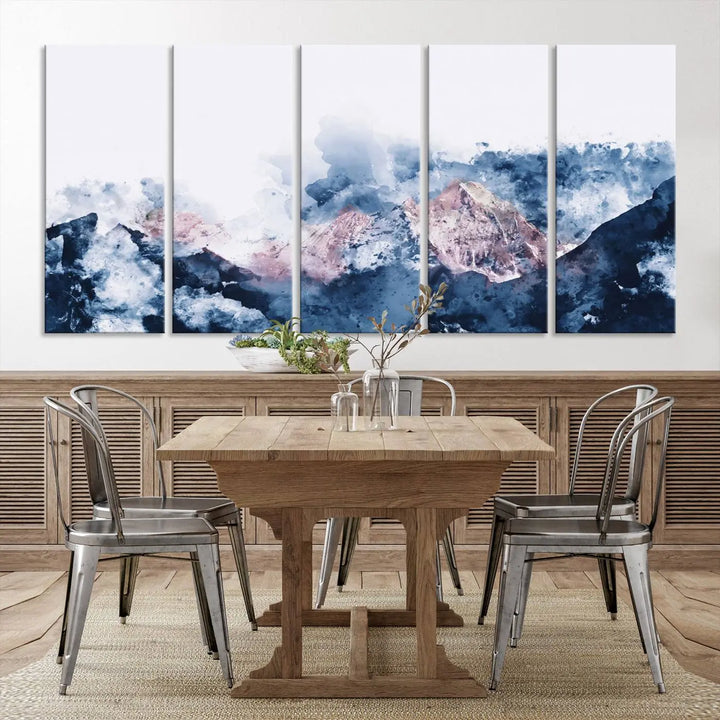 The modern living room features a framed triptych art on a dark wall, complemented by the Abstract Watercolor Mountain Landscape Art Canvas Print, which adds elegance and depth to the space.