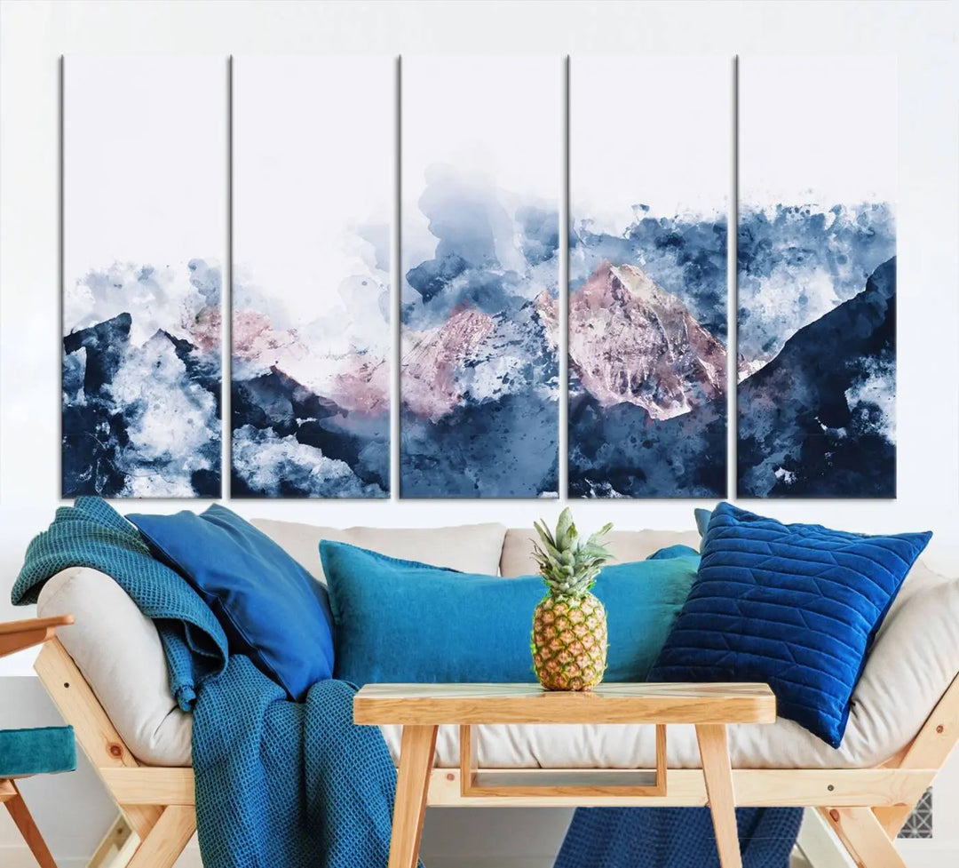 The modern living room features a framed triptych art on a dark wall, complemented by the Abstract Watercolor Mountain Landscape Art Canvas Print, which adds elegance and depth to the space.