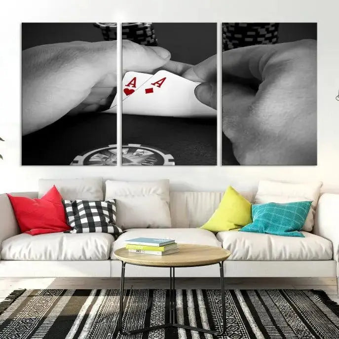 The living room wall is accentuated by the Ace of Hearts Poker Canvas Wall Art - Triptych Black and White Poker Hand Decor, ready to hang. This art piece captures a striking image of two hands holding a pair of aces, including the Ace of Hearts.