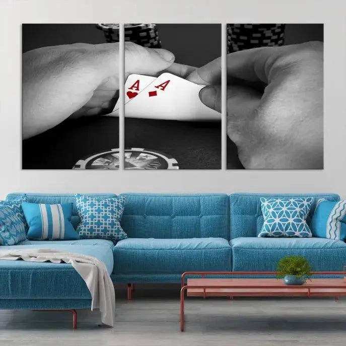 The living room wall is accentuated by the Ace of Hearts Poker Canvas Wall Art - Triptych Black and White Poker Hand Decor, ready to hang. This art piece captures a striking image of two hands holding a pair of aces, including the Ace of Hearts.