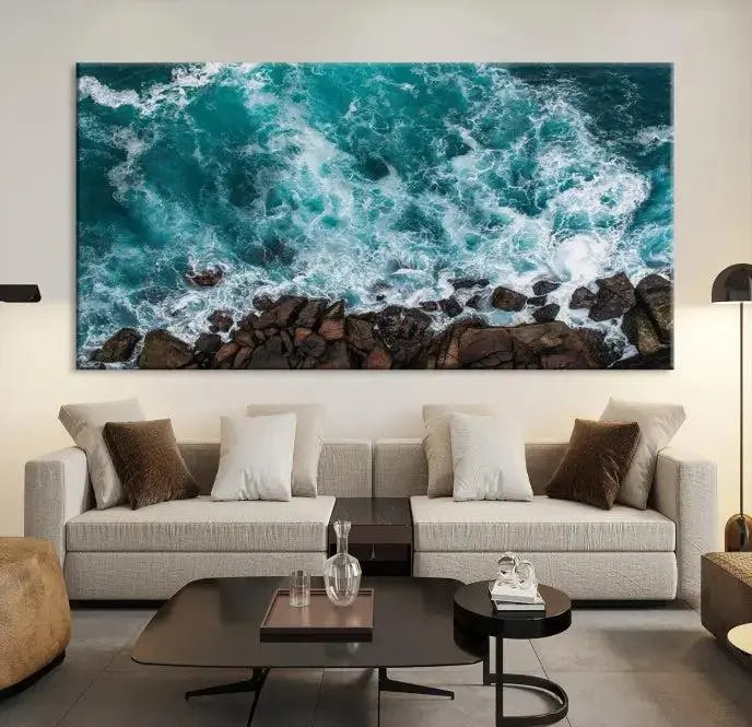 The Aerial Ocean Waves Wall Art Canvas Print is showcased on gallery-wrapped, museum-quality canvases, depicting a triptych of ocean waves crashing on rocks.