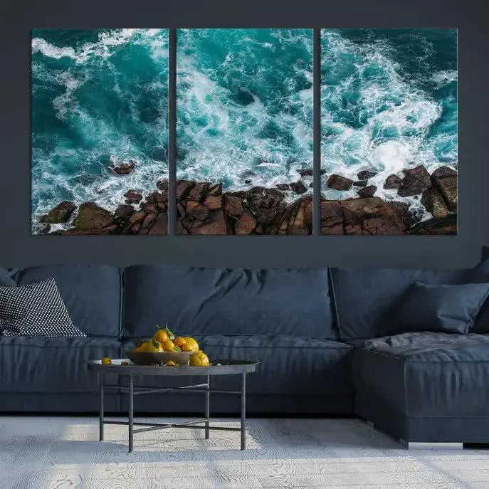 The Aerial Ocean Waves Wall Art Canvas Print is showcased on gallery-wrapped, museum-quality canvases, depicting a triptych of ocean waves crashing on rocks.