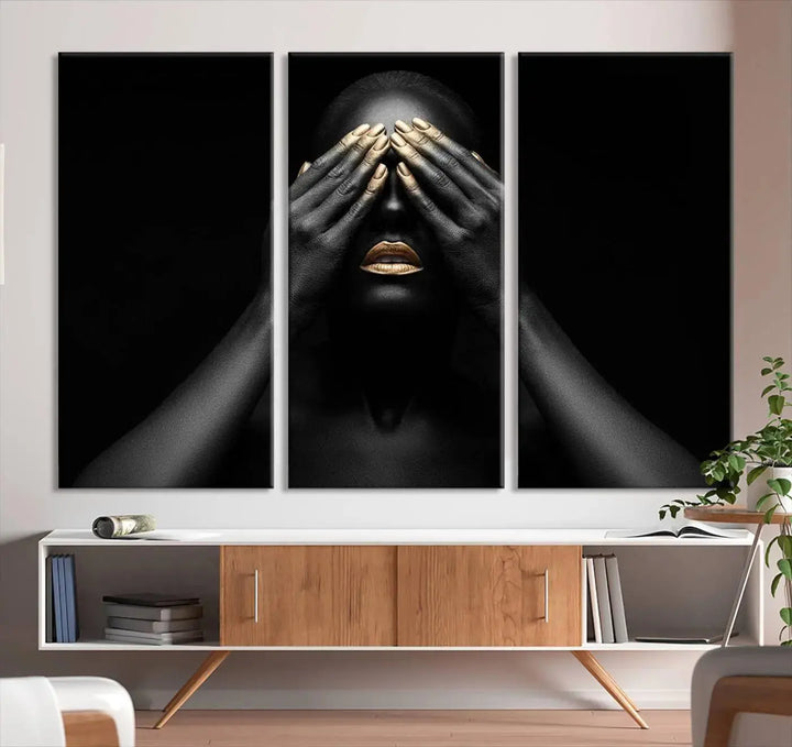 The African American Art Black and White Canvas Wall Art Gold Lips Art is a striking triptych featuring a woman with gold lips and nails covering her eyes.