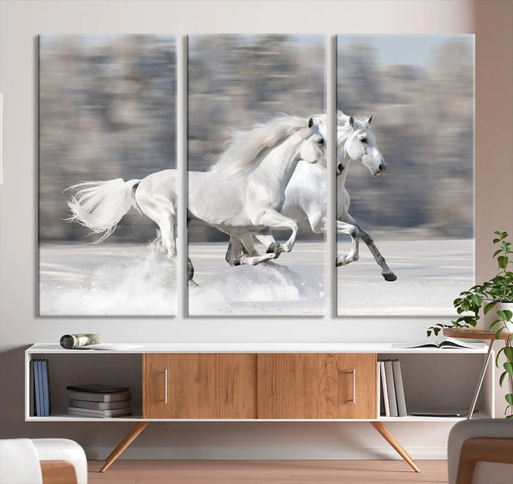 The "All The White Horses Wall Art Canvas Print" depicts a triptych of galloping white horses across a snowy landscape. These museum-quality canvases come with a UV-protective coating to maintain their stunning appearance over time.