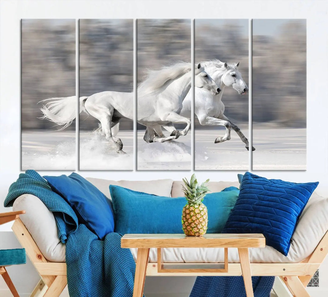 The "All The White Horses Wall Art Canvas Print" depicts a triptych of galloping white horses across a snowy landscape. These museum-quality canvases come with a UV-protective coating to maintain their stunning appearance over time.