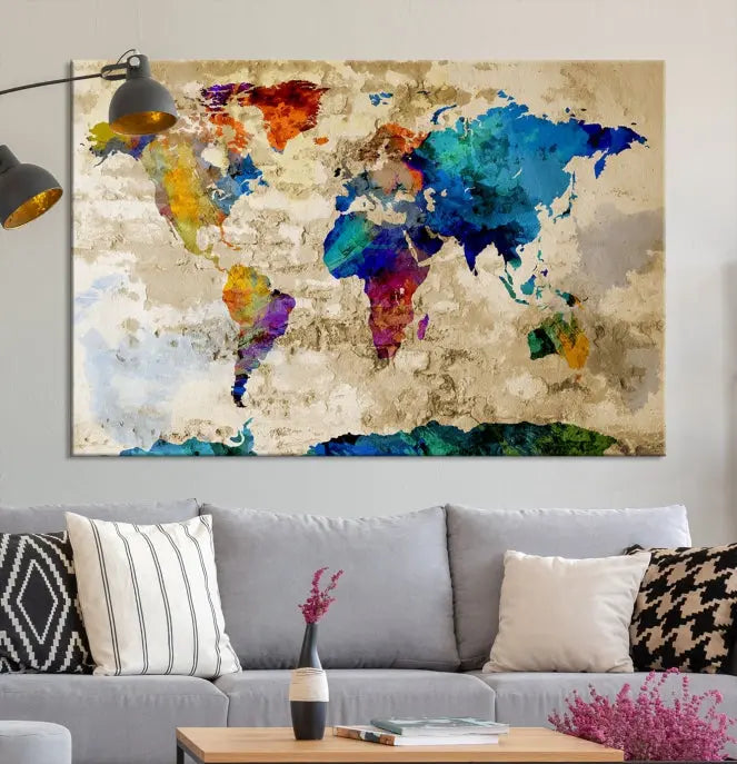 A three-panel "Watercolor Wall Art World Map w/ Antarctica Canvas Print" on museum-quality canvas features vibrant colors and is ready to hang in a dimly lit living room.