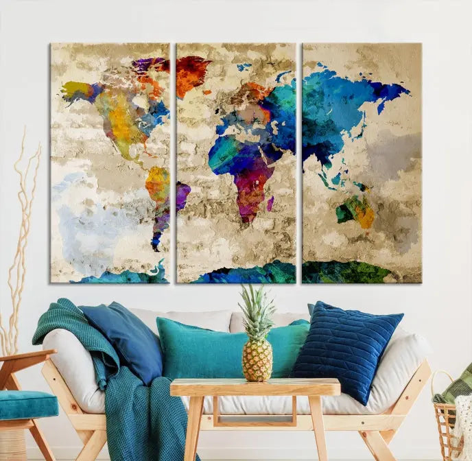 A three-panel "Watercolor Wall Art World Map w/ Antarctica Canvas Print" on museum-quality canvas features vibrant colors and is ready to hang in a dimly lit living room.