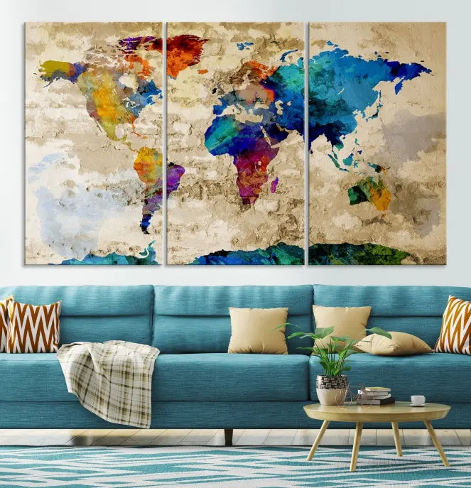 A three-panel "Watercolor Wall Art World Map w/ Antarctica Canvas Print" on museum-quality canvas features vibrant colors and is ready to hang in a dimly lit living room.