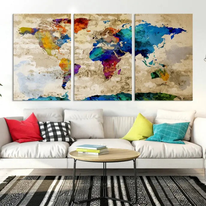 A three-panel "Watercolor Wall Art World Map w/ Antarctica Canvas Print" on museum-quality canvas features vibrant colors and is ready to hang in a dimly lit living room.