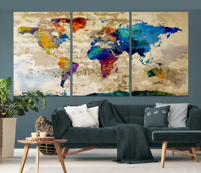 A three-panel "Watercolor Wall Art World Map w/ Antarctica Canvas Print" on museum-quality canvas features vibrant colors and is ready to hang in a dimly lit living room.