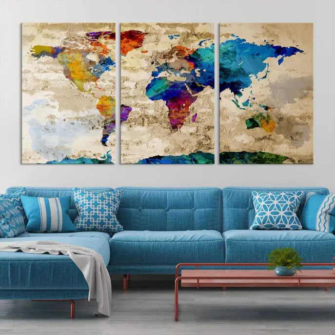 A three-panel "Watercolor Wall Art World Map w/ Antarctica Canvas Print" on museum-quality canvas features vibrant colors and is ready to hang in a dimly lit living room.