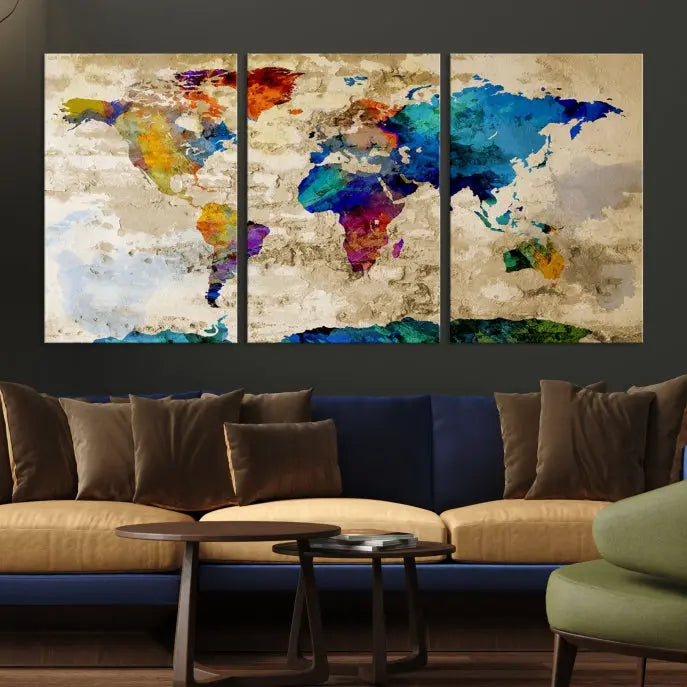 A three-panel "Watercolor Wall Art World Map w/ Antarctica Canvas Print" on museum-quality canvas features vibrant colors and is ready to hang in a dimly lit living room.