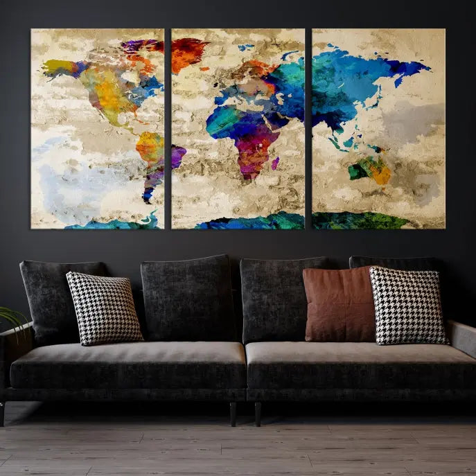 A three-panel "Watercolor Wall Art World Map w/ Antarctica Canvas Print" on museum-quality canvas features vibrant colors and is ready to hang in a dimly lit living room.