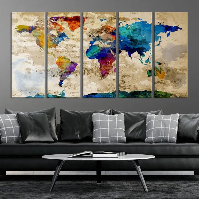 A three-panel "Watercolor Wall Art World Map w/ Antarctica Canvas Print" on museum-quality canvas features vibrant colors and is ready to hang in a dimly lit living room.