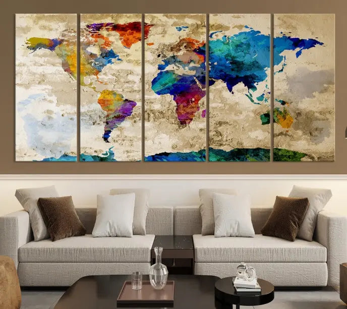 A three-panel "Watercolor Wall Art World Map w/ Antarctica Canvas Print" on museum-quality canvas features vibrant colors and is ready to hang in a dimly lit living room.