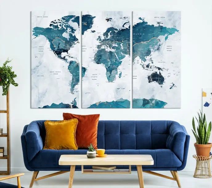 A Push Pin World Map with Antarctica, printed on museum-quality canvas portraying blue oceans, is displayed as a triptych above a dark wall.