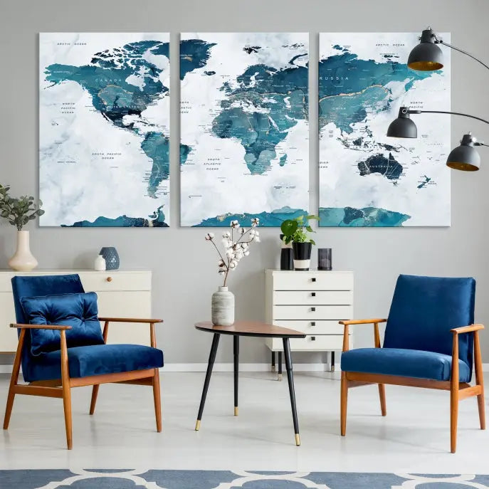 A Push Pin World Map with Antarctica, printed on museum-quality canvas portraying blue oceans, is displayed as a triptych above a dark wall.