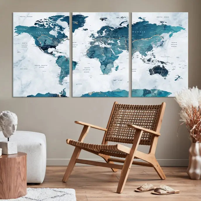 A Push Pin World Map with Antarctica, printed on museum-quality canvas portraying blue oceans, is displayed as a triptych above a dark wall.