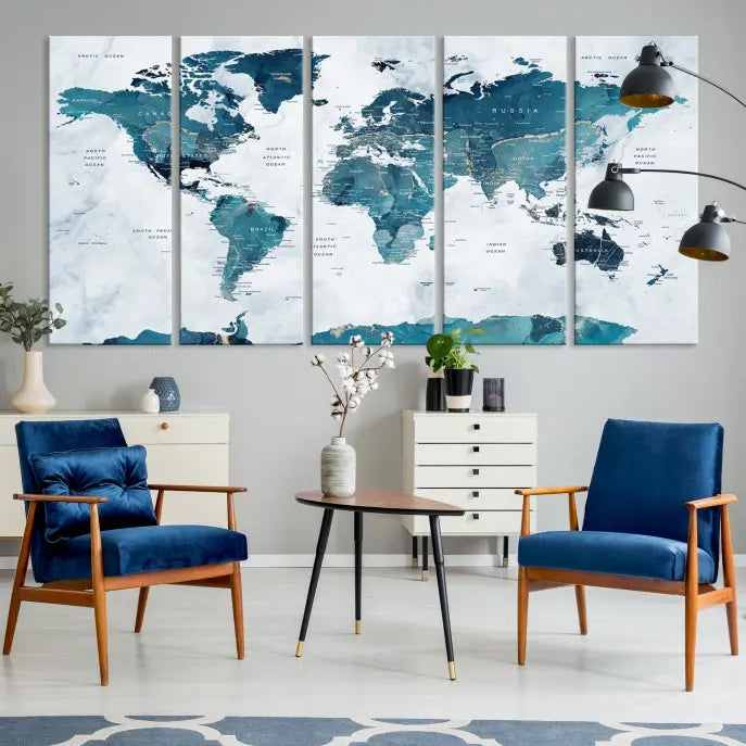 A Push Pin World Map with Antarctica, printed on museum-quality canvas portraying blue oceans, is displayed as a triptych above a dark wall.