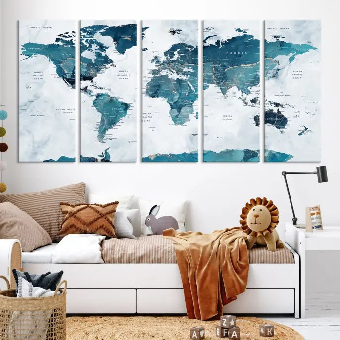 A Push Pin World Map with Antarctica, printed on museum-quality canvas portraying blue oceans, is displayed as a triptych above a dark wall.