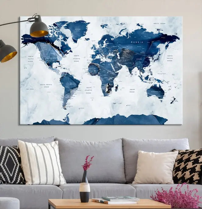 The Navy Blue World Map with Antarctica Wall Art Canvas Print, featuring a stunning blend of blue and white on a museum-quality canvas, elegantly adorns a dark wall. This ready-to-hang masterpiece enhances the room's sophisticated ambiance.