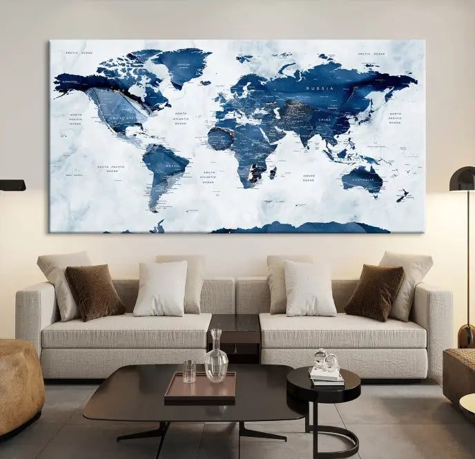 The Navy Blue World Map with Antarctica Wall Art Canvas Print, featuring a stunning blend of blue and white on a museum-quality canvas, elegantly adorns a dark wall. This ready-to-hang masterpiece enhances the room's sophisticated ambiance.