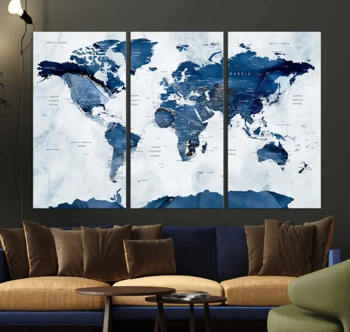 The Navy Blue World Map with Antarctica Wall Art Canvas Print, featuring a stunning blend of blue and white on a museum-quality canvas, elegantly adorns a dark wall. This ready-to-hang masterpiece enhances the room's sophisticated ambiance.